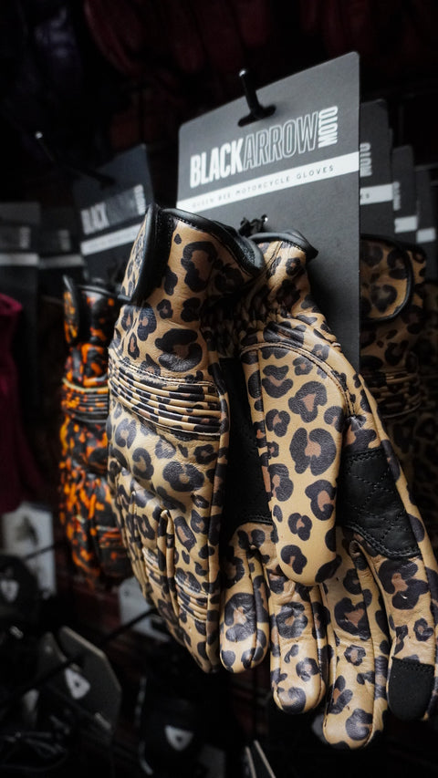 Leopard print gloves with tag on a dark background